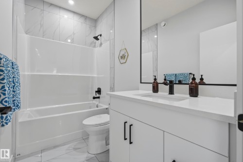White vanity with integrated sink, white countertop, and matte black faucet - 7314 Morgan Road Nw, Edmonton, AB - Indoor Photo Showing Bathroom