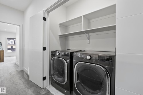 Laundry closet with stacked shelving and tile flooring - 7314 Morgan Road Nw, Edmonton, AB - Indoor Photo Showing Laundry Room