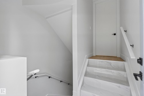 Staircase with white marble-look treads, white risers, and white walls - 7314 Morgan Road Nw, Edmonton, AB - Indoor Photo Showing Other Room