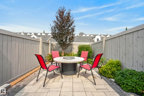 Paved patio area featuring a built-in fire pit, privacy fencing, and landscaping - 7314 Morgan Road Nw, Edmonton, AB - Outdoor