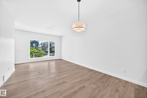 Large window, wood-finish flooring, recessed lighting, drum pendant light fixture, white trim - 3816 Chrustawka Place Sw, Edmonton, AB - Indoor