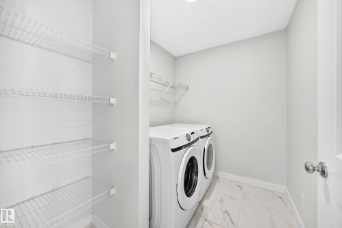 Laundry area featuring a side-by-side washer and dryer, tile flooring, and wire shelving - 3816 Chrustawka Place Sw, Edmonton, AB - Indoor Photo Showing Laundry Room