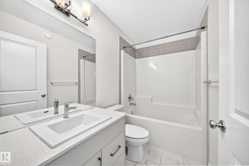 White vanity with an integrated rectangular sink and chrome faucet - 3816 Chrustawka Place Sw, Edmonton, AB - Indoor Photo Showing Bathroom