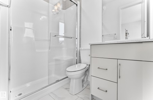 Tiled flooring, modern vanity with countertop, frameless mirror, chrome faucet, and glass-enclosed shower - 3816 Chrustawka Place Sw, Edmonton, AB - Indoor Photo Showing Bathroom
