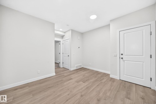 Neutral wall color, wood-finish flooring, recessed ceiling lighting, and white trim - 3816 Chrustawka Place Sw, Edmonton, AB - Indoor Photo Showing Other Room