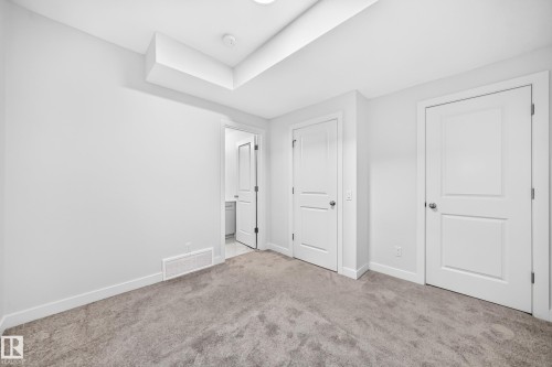 Light gray wall paint, recessed ceiling light, white trim, gray carpet, white interior doors - 3816 Chrustawka Place Sw, Edmonton, AB - Indoor Photo Showing Other Room