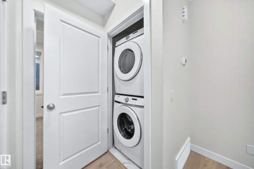 Integrated stacked washer and dryer in a dedicated utility closet - 3816 Chrustawka Place Sw, Edmonton, AB - Indoor Photo Showing Laundry Room