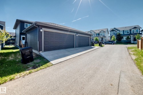 Detached two-car garage with panel doors and concrete driveway - 3816 Chrustawka Place Sw, Edmonton, AB - Outdoor