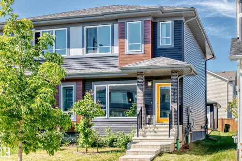 Contemporary exterior with mixed siding, a covered entry, and a bright yellow door - 3816 Chrustawka Place Sw, Edmonton, AB - Outdoor