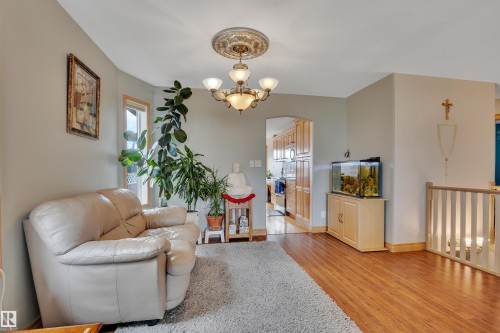 Wood-finish flooring, an arched doorway, and a decorative ceiling medallion with a chandelier - 4224 53 Ave, Wetaskiwin, AB - Indoor