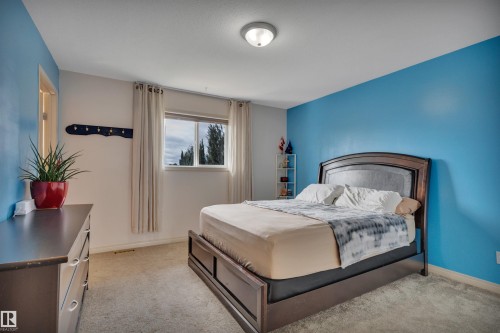 Recessed window with drapes, wall-mounted light fixture, and carpet flooring - 4224 53 Ave, Wetaskiwin, AB - Indoor Photo Showing Bedroom