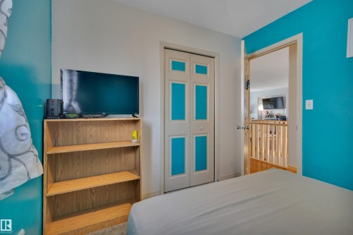 Bi-fold closet doors with decorative paneling - 4224 53 Ave, Wetaskiwin, AB - Indoor Photo Showing Bedroom