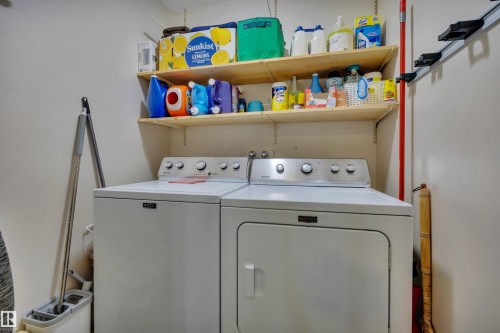 Laundry area featuring a side-by-side washer and dryer, along with two wall-mounted shelving units - 4224 53 Ave, Wetaskiwin, AB - Indoor Photo Showing Laundry Room