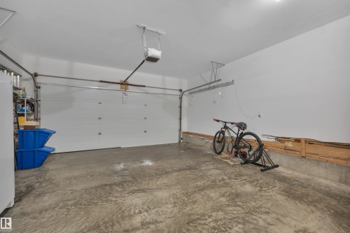 Spacious garage featuring a concrete floor, white walls, and an automatic garage door opener - 4224 53 Ave, Wetaskiwin, AB - Indoor Photo Showing Garage