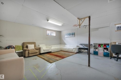 Finished interior space featuring concrete flooring, a utility window, and fluorescent lighting - 4224 53 Ave, Wetaskiwin, AB - Indoor