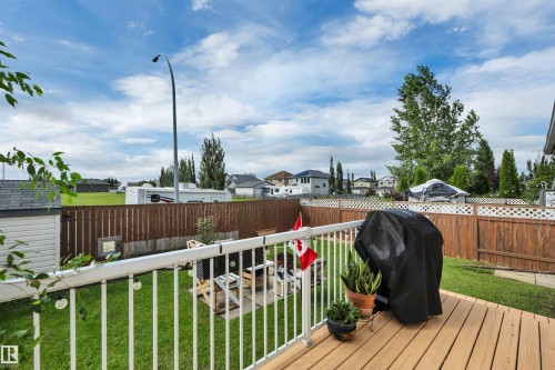 Hardwood deck with white railing, manicured lawn, wood fencing, and storage shed - 4224 53 Ave, Wetaskiwin, AB - Outdoor With Deck Patio Veranda
