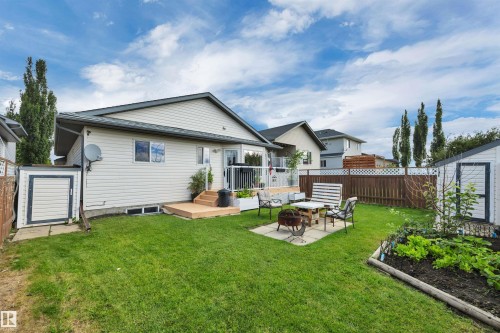 Expansive lawn with a raised garden bed, paver patio, and storage shed - 4224 53 Ave, Wetaskiwin, AB - Outdoor With Deck Patio Veranda