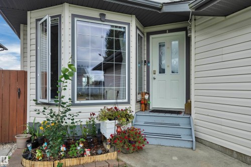 Bay window with white framing, front entry door with decorative glass inserts, and light-colored siding - 4224 53 Ave, Wetaskiwin, AB - Outdoor