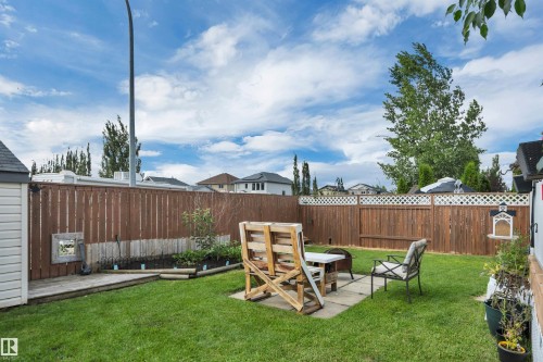 Expansive backyard featuring a manicured lawn, wood fencing, and a storage shed - 4224 53 Ave, Wetaskiwin, AB - Outdoor With Deck Patio Veranda