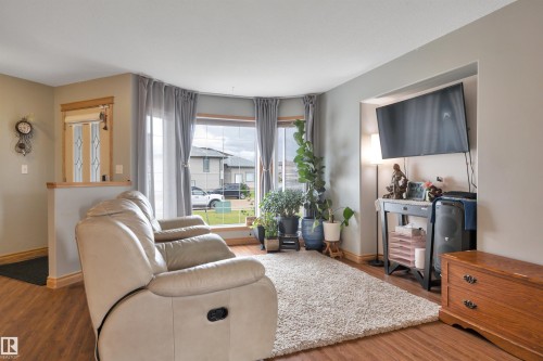 Bay window, wood-finish flooring, half wall partition, light neutral wall paint, white ceiling - 4224 53 Ave, Wetaskiwin, AB - Indoor Photo Showing Living Room