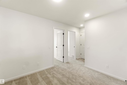 Neutral-toned interior room with plush carpet flooring, white walls, and recessed lighting - 265 Chappelle Drive Sw, Edmonton, AB - Indoor Photo Showing Other Room