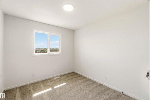 Neutral tone walls with an overhead flush-mount light fixture - 265 Chappelle Drive Sw, Edmonton, AB - Indoor Photo Showing Other Room