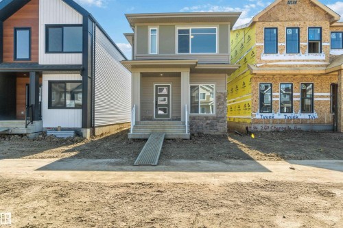 Contemporary two-story exterior featuring a neutral palette, stone accent siding, and multiple windows - 265 Chappelle Drive Sw, Edmonton, AB - Outdoor With Facade