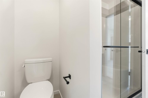 White toilet with matte black toilet paper holder - 265 Chappelle Drive Sw, Edmonton, AB - Indoor Photo Showing Bathroom