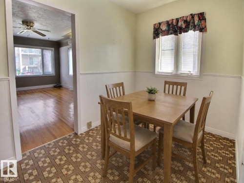 Bright window with white blinds, wainscoting, and patterned flooring - 11336 83 Street Nw, Edmonton, AB - Indoor Photo Showing Dining Room
