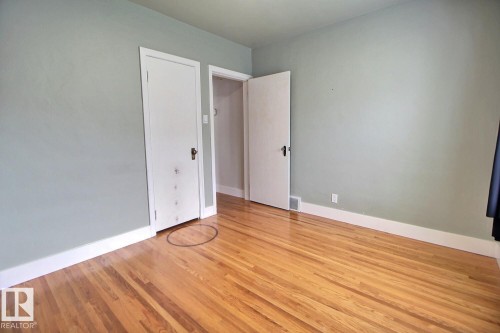 Hardwood flooring, painted walls, white trim, and white doors - 11336 83 Street Nw, Edmonton, AB - Indoor Photo Showing Other Room