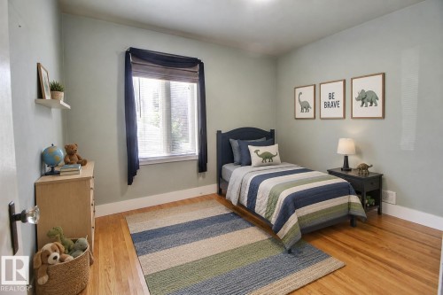 Hardwood flooring throughout, featuring a window with blinds, and light-toned walls - 11336 83 Street Nw, Edmonton, AB - Indoor Photo Showing Bedroom