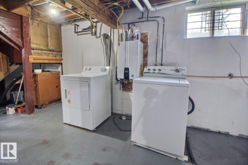 Laundry area featuring a washer and dryer, exposed ceiling beams, and a window - 11336 83 Street Nw, Edmonton, AB - Indoor Photo Showing Laundry Room