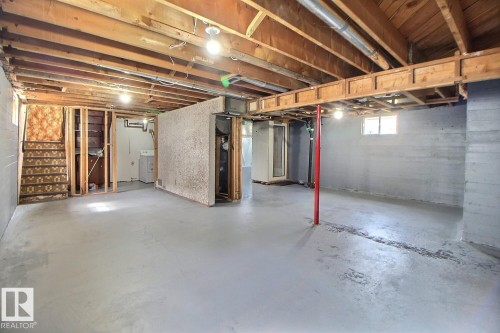 Spacious unfinished basement with exposed wooden ceiling beams, concrete flooring, and multiple windows - 11336 83 Street Nw, Edmonton, AB - Indoor Photo Showing Basement