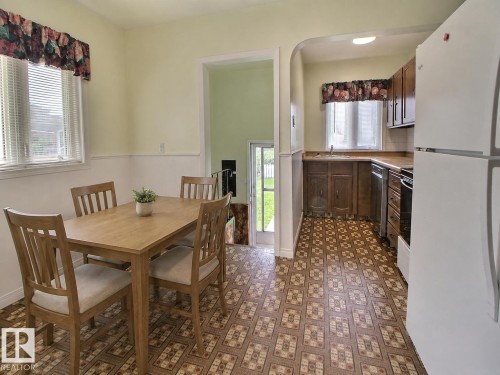 Eat-in kitchen featuring wood-finish cabinetry, a white refrigerator, and a built-in oven - 11336 83 Street Nw, Edmonton, AB - Indoor Photo Showing Dining Room