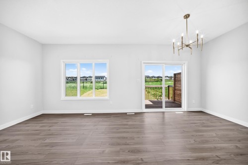 Wood-finish flooring, white walls, modern chandelier, white trim, sliding glass door - 8823 Carson Way Sw, Edmonton, AB - Indoor
