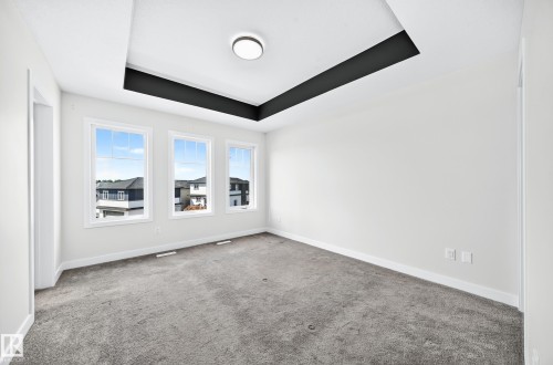 Tray ceiling with dark accent, recessed lighting, triple windows, and neutral carpet flooring - 8823 Carson Way Sw, Edmonton, AB - Indoor Photo Showing Other Room