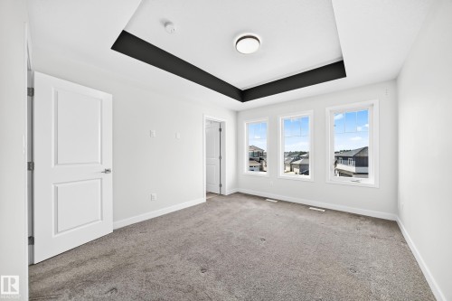 Recessed ceiling with contrasting trim, three panel windows, flush mount ceiling lighting, and carpet flooring - 8823 Carson Way Sw, Edmonton, AB - Indoor Photo Showing Other Room