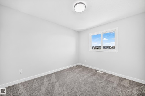 Neutral wall color with a contrasting white trim, carpeted flooring, and a single window - 8823 Carson Way Sw, Edmonton, AB - Indoor Photo Showing Other Room