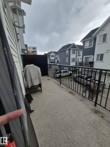 Concrete balcony with black metal railings and exterior wall lighting - Edmonton, AB - Outdoor With Exterior