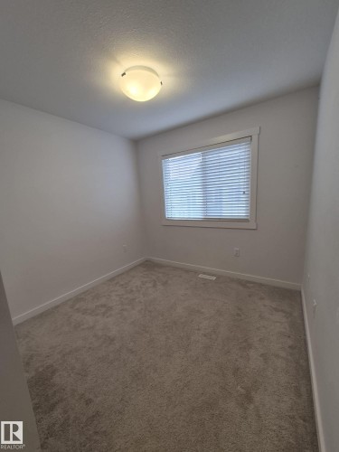 Neutral-toned carpeting with white wall paint - Edmonton, AB - Indoor Photo Showing Other Room