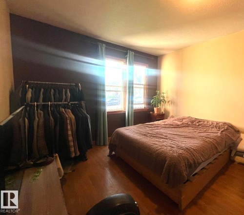 Hardwood-finish flooring, dual windows with natural light, and a built-in wall shelf - 9828 84 Avenue Nw, Edmonton, AB - Indoor Photo Showing Bedroom