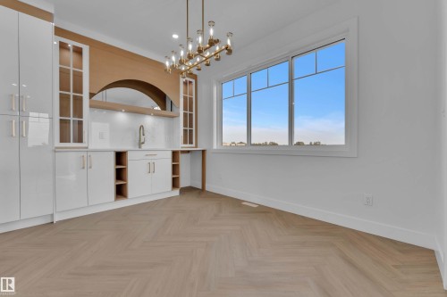 Herringbone wood-finish flooring complements the modern chandelier - 465 Crystal Creek Link, Leduc, AB - Indoor Photo Showing Other Room