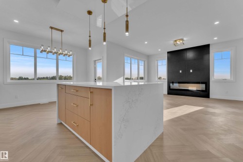 Kitchen island with wood-finish cabinetry and a white countertop - 465 Crystal Creek Link, Leduc, AB - Indoor Photo Showing Other Room
