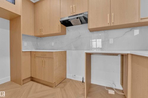 Light wood-finish cabinetry, sleek white countertops, and a white marble-look backsplash - 465 Crystal Creek Link, Leduc, AB - Indoor Photo Showing Other Room