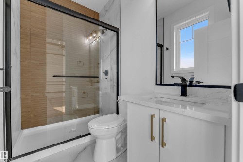 Shower/tub combination with sliding glass door, vanity with countertop, undermount sink, and black fixtures - 465 Crystal Creek Link, Leduc, AB - Indoor Photo Showing Bathroom
