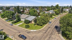 Suburban setting featuring an established residential street, mature trees, and a clear sky - 