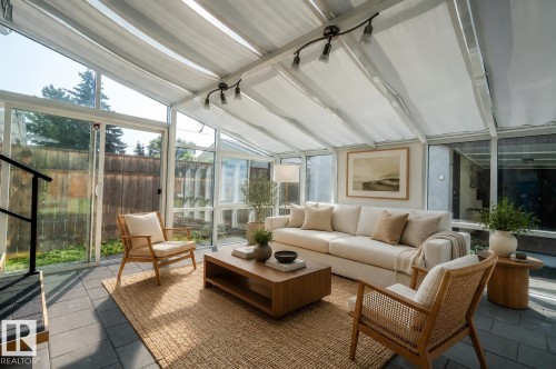 Sunroom with a glass and retractable fabric roof, floor-to-ceiling windows, and dark tile flooring - 3829 113 Avenue Nw, Edmonton, AB - Indoor Photo Showing Living Room