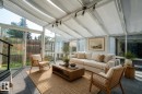 Sunroom with a glass and retractable fabric roof, floor-to-ceiling windows, and dark tile flooring - 3829 113 Avenue Nw, Edmonton, AB  - Indoor Photo Showing Living Room 