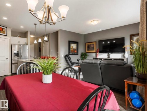 Open-concept living area featuring wood-finish flooring and a contemporary chandelier - 12737 205 Street Nw, Edmonton, AB - Indoor Photo Showing Dining Room