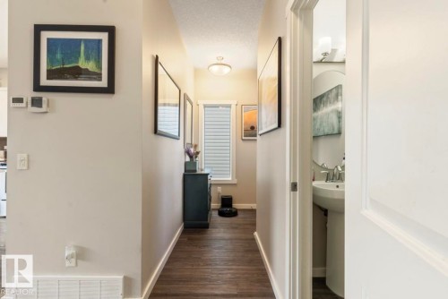 Hallway with wood-finish flooring, white trim, and a window with blinds - 12737 205 Street Nw, Edmonton, AB - Indoor Photo Showing Other Room